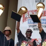 Dennis Rodman, Michael Jordan y Scottie Pippen muestran 3 trofeos del campeonato de la NBA 1997.