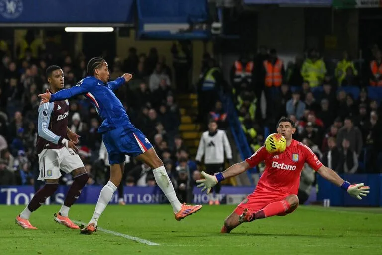 Emiliano Martínez le pone el cuerpo a la definición de João Pedro y con la cara impedirá un gol del brasileño en Chelsea 1 vs. Aston Villa 2, por la Premier League. - Créditos: @GLYN KIRK